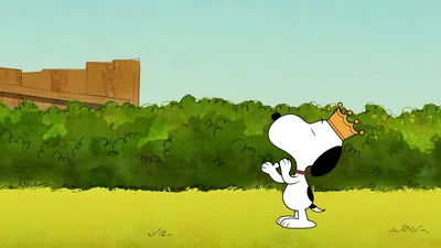 Snoopy wearing a golden crown in a lush green field for PC Wallpaper